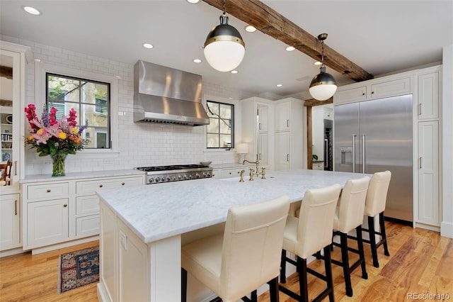 535 N High St, Denver, CO 80218 - kitchen with wall chimney range hood, stainless steel built in fridge, a sink, light wood-type flooring, and beam ceiling