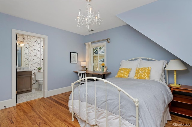 535 N High St, Denver, CO 80218 - bedroom with baseboards, wood finished floors, a chandelier, and ensuite bath