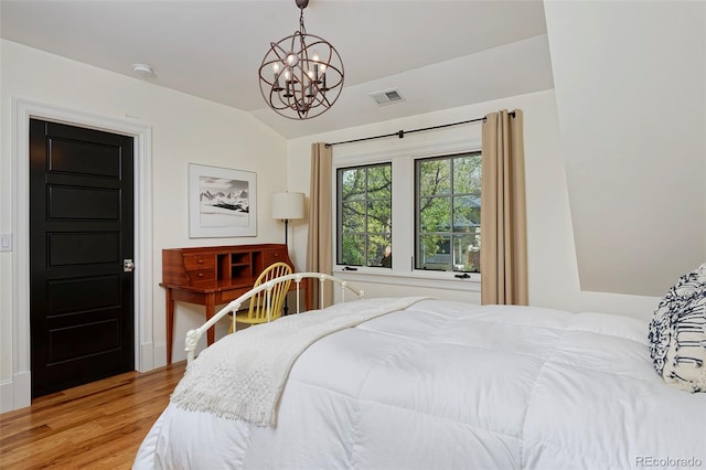 535 N High St, Denver, CO 80218 - bedroom with vaulted ceiling, wood finished floors, and a chandelier