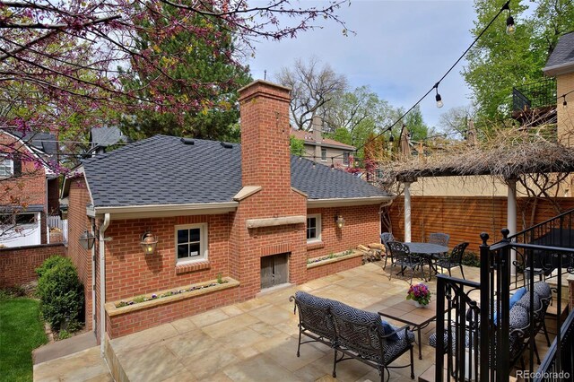 535 N High St, Denver, CO 80218 - view of patio / terrace with a brick fireplace, fence, and outdoor dining space