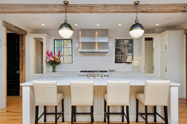 535 N High St, Denver, CO 80218 - kitchen featuring wall chimney exhaust hood, decorative backsplash, light wood-style flooring, recessed lighting, and white cabinetry