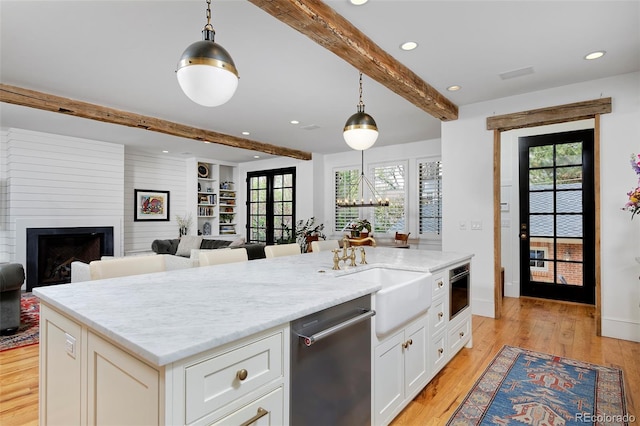 535 N High St, Denver, CO 80218 - kitchen featuring dishwasher, beam ceiling, a sink, light wood-type flooring, and white cabinets