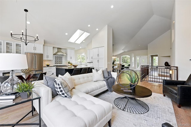 1361 Castlepoint Cir, Castle Pines, CO 80108 - living room featuring high vaulted ceiling, a chandelier, light wood-style floors, a skylight, and recessed lighting