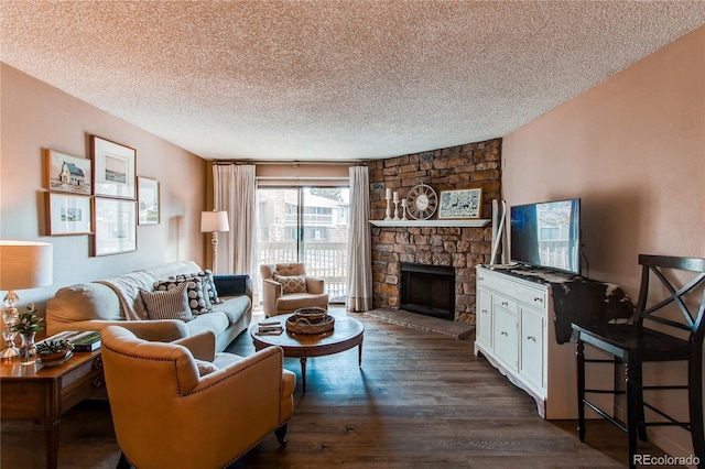 living room with dark wood-type flooring, a textured ceiling, and a stone fireplace