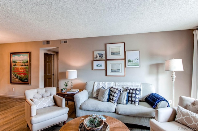 living room with hardwood / wood-style flooring and a textured ceiling