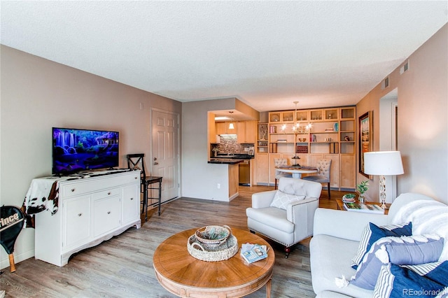 living room featuring light wood-type flooring and a textured ceiling