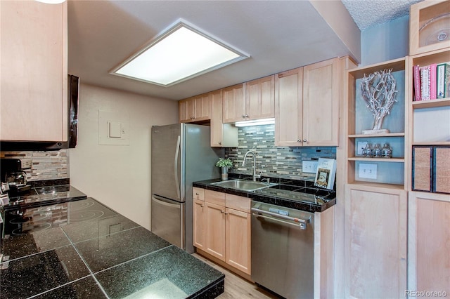 kitchen with sink, appliances with stainless steel finishes, light brown cabinets, and tasteful backsplash