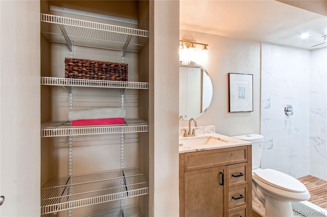 bathroom with toilet, vanity, and walk in shower