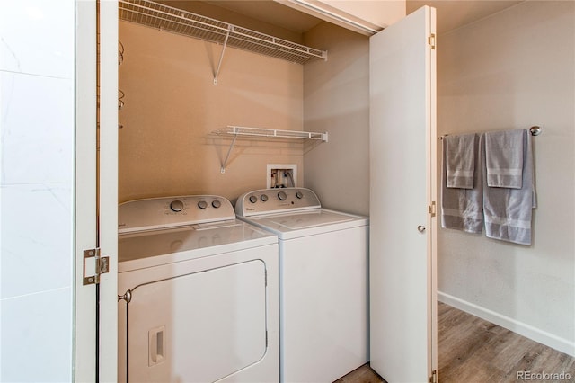 laundry room with hardwood / wood-style flooring and washer and clothes dryer