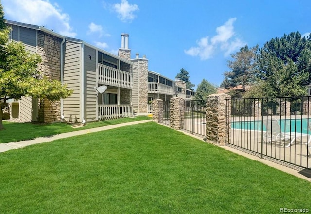 view of property's community featuring a yard and a pool