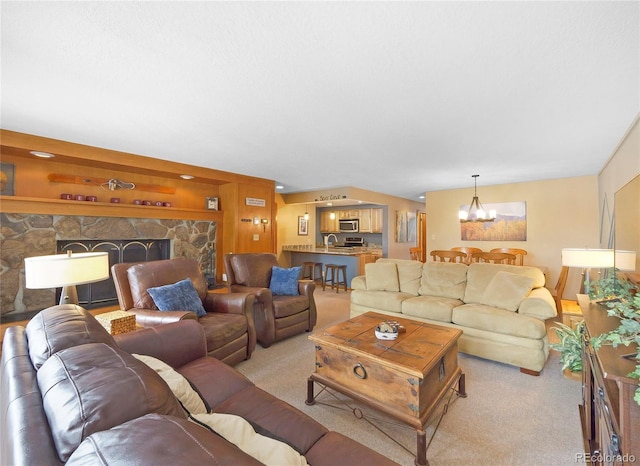 carpeted living room with built in shelves, a stone fireplace, and a chandelier