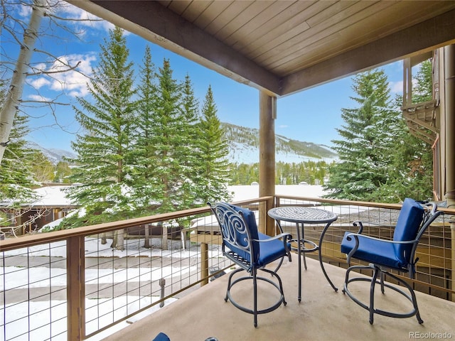 snow covered back of property with a mountain view