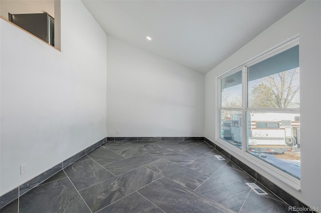 unfurnished room featuring vaulted ceiling