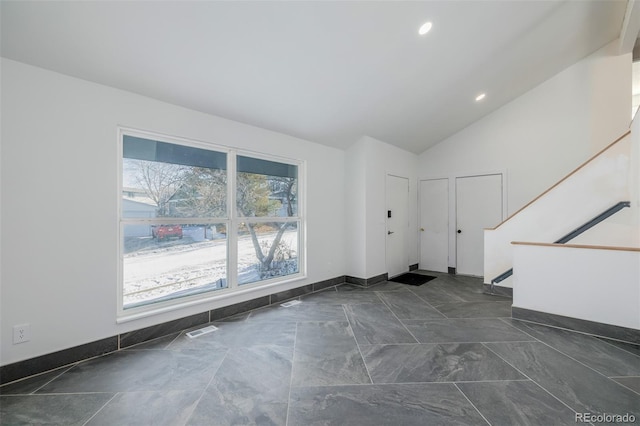 unfurnished living room featuring high vaulted ceiling