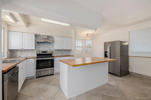 kitchen with white cabinetry, wood counters, appliances with stainless steel finishes, and wall chimney exhaust hood