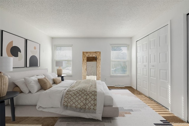 bedroom featuring hardwood / wood-style flooring, a closet, and a textured ceiling