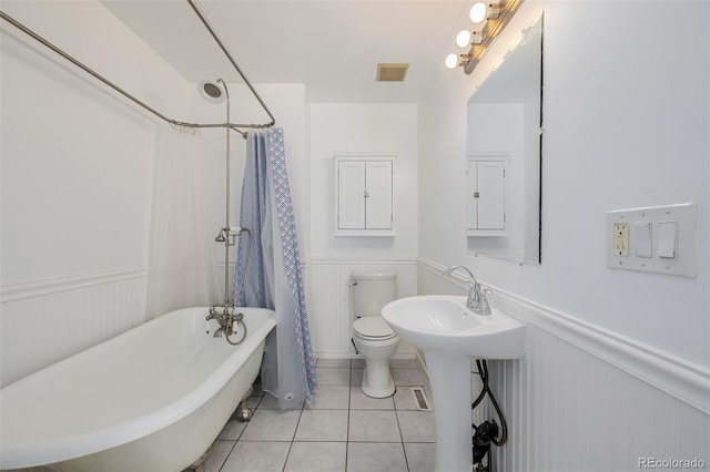 bathroom featuring shower / bath combination with curtain, toilet, and tile patterned flooring