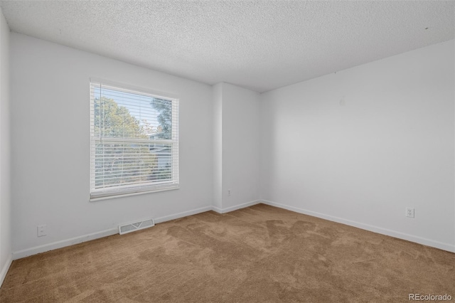 carpeted spare room featuring a textured ceiling