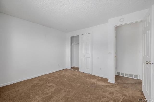 unfurnished bedroom featuring a closet, a textured ceiling, and carpet