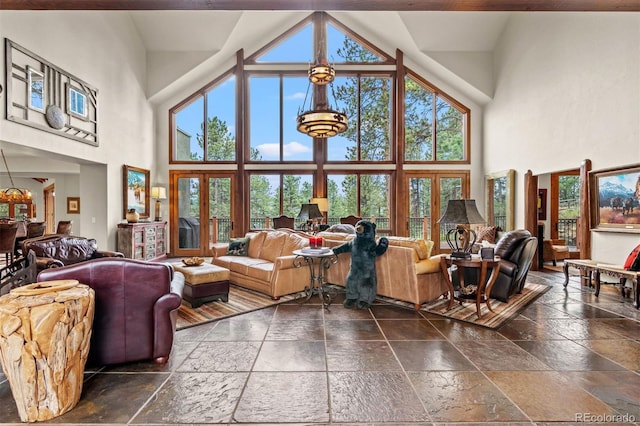 living room with a chandelier, high vaulted ceiling, and french doors