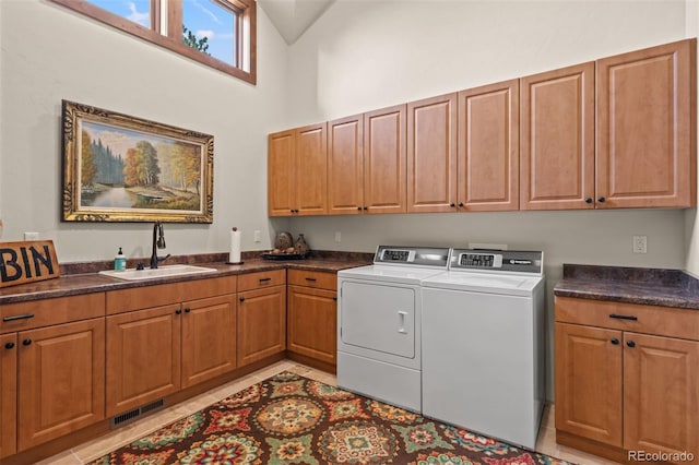 washroom with cabinets, a high ceiling, sink, washing machine and dryer, and light tile patterned floors