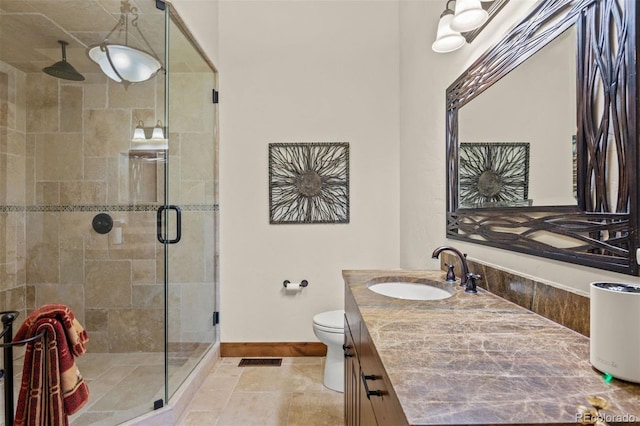 bathroom with vanity, toilet, and an enclosed shower