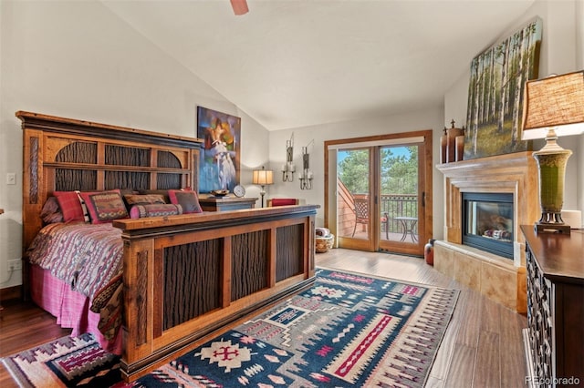 bedroom featuring ceiling fan, light hardwood / wood-style floors, access to exterior, and lofted ceiling