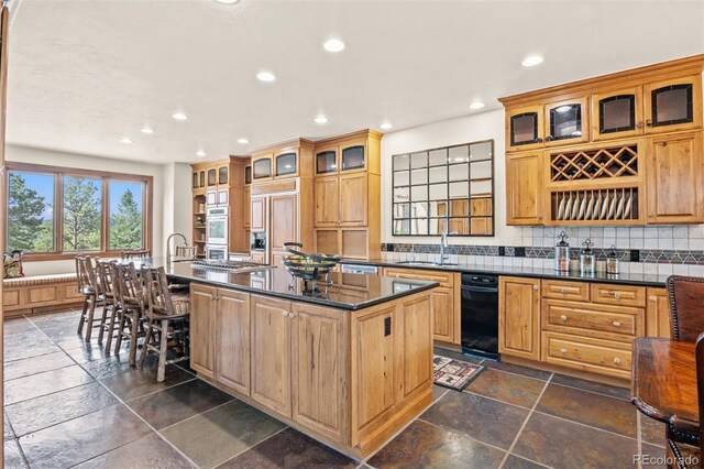 kitchen featuring decorative backsplash and a center island with sink