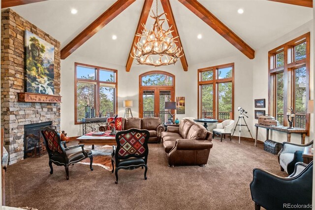 carpeted living room with beam ceiling, high vaulted ceiling, plenty of natural light, a chandelier, and a fireplace