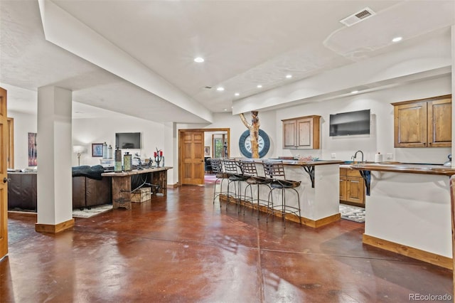 kitchen featuring a kitchen island, sink, and a breakfast bar area