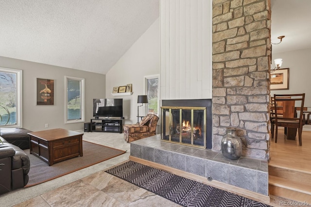 living room featuring high vaulted ceiling, a fireplace, plenty of natural light, and a textured ceiling