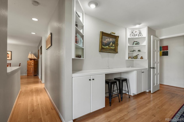 hall with light wood-type flooring, baseboards, built in features, and recessed lighting