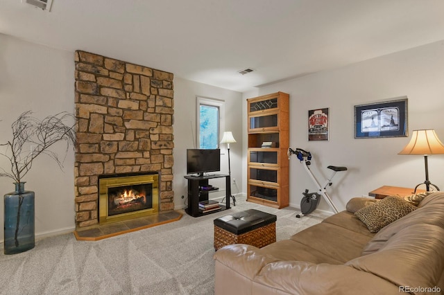 carpeted living room featuring baseboards, visible vents, and a stone fireplace