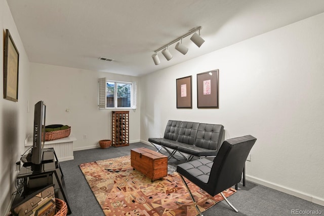 living room featuring carpet floors, baseboards, visible vents, and track lighting