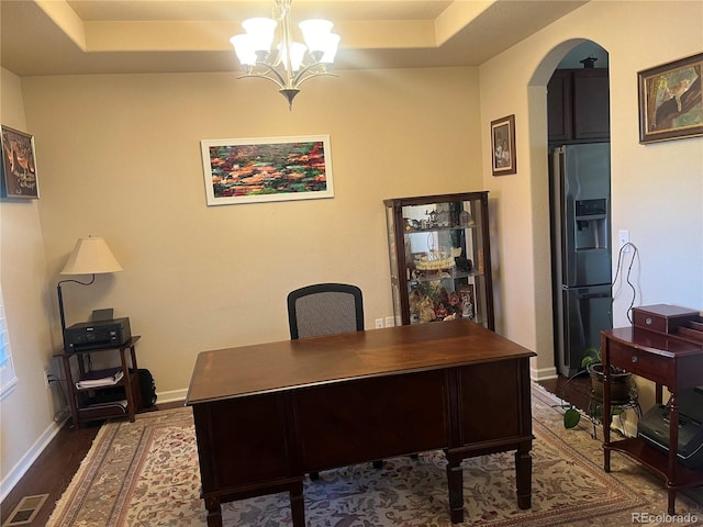 office with a notable chandelier, a raised ceiling, and dark hardwood / wood-style floors