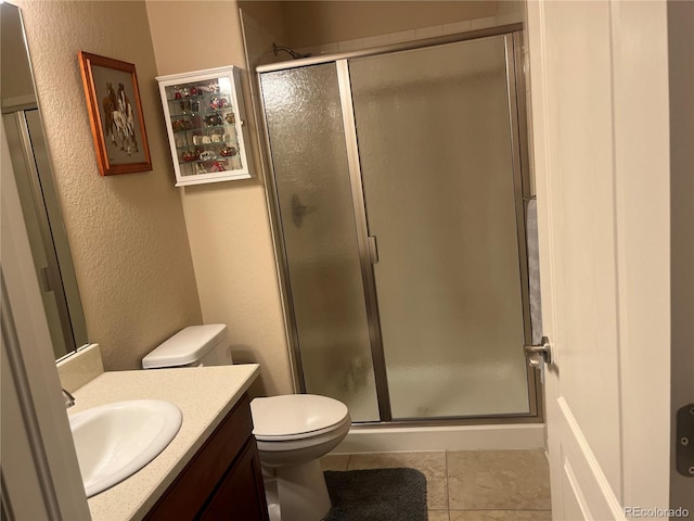 bathroom with vanity, tile patterned floors, toilet, and an enclosed shower