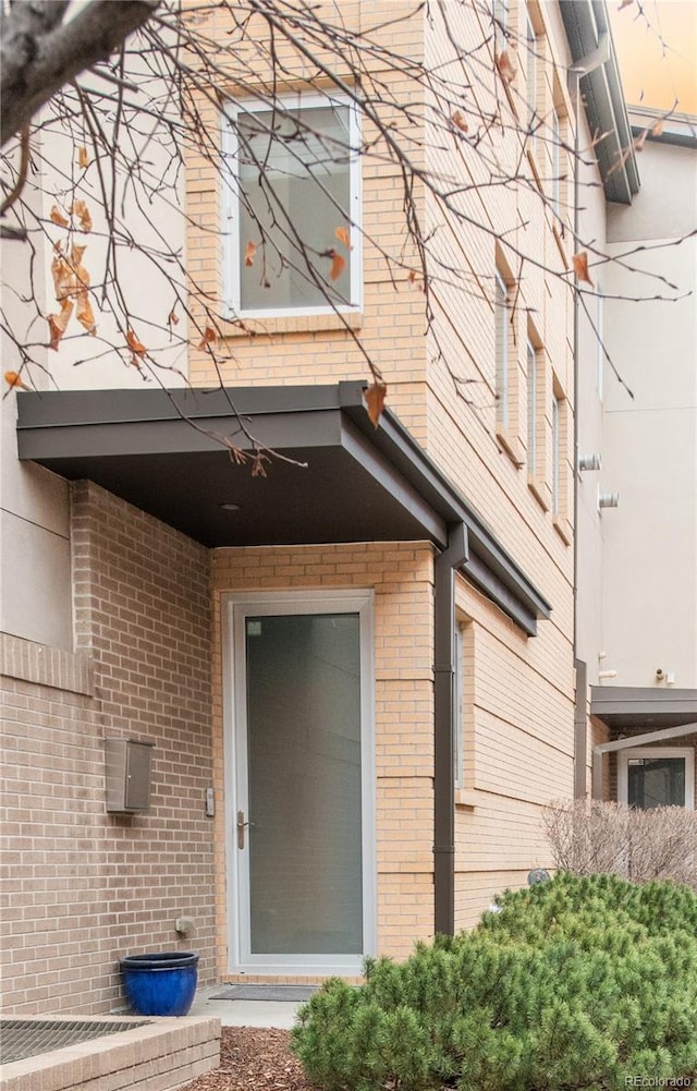 view of exterior entry with brick siding