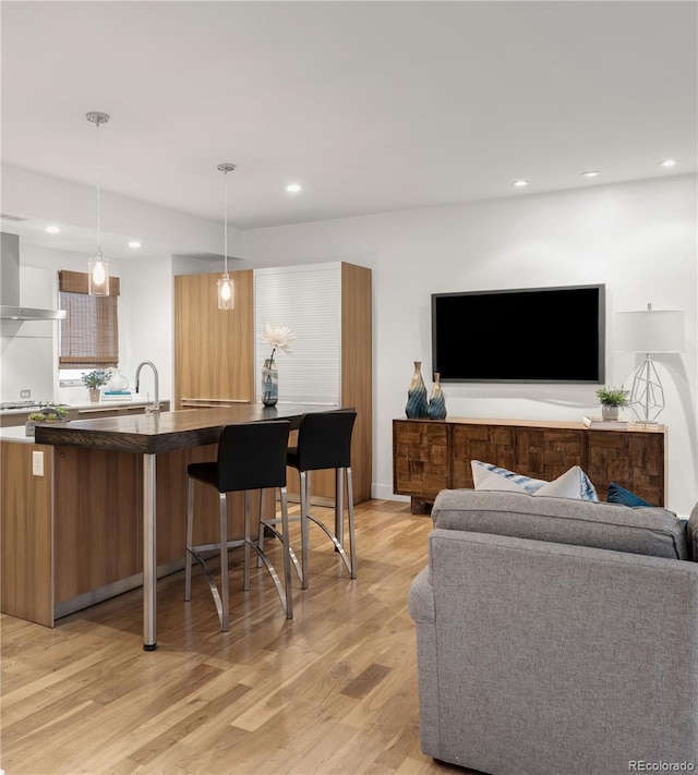 living area with recessed lighting and light wood finished floors