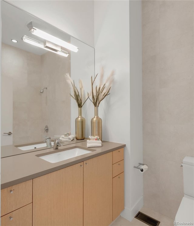 full bathroom featuring a shower, visible vents, toilet, and vanity