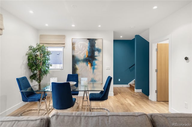 dining area featuring wood finished floors, recessed lighting, stairs, and baseboards