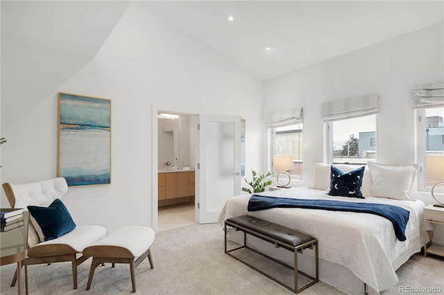 bedroom featuring high vaulted ceiling, light colored carpet, connected bathroom, a sink, and recessed lighting