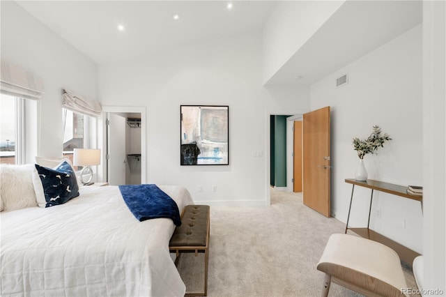 bedroom featuring light colored carpet, recessed lighting, a towering ceiling, baseboards, and a spacious closet