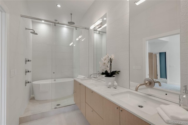 bathroom with a tile shower, a soaking tub, and double vanity