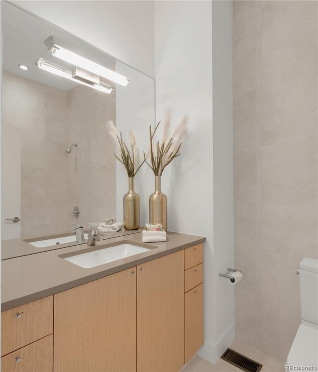 full bathroom with toilet, vanity, and a shower