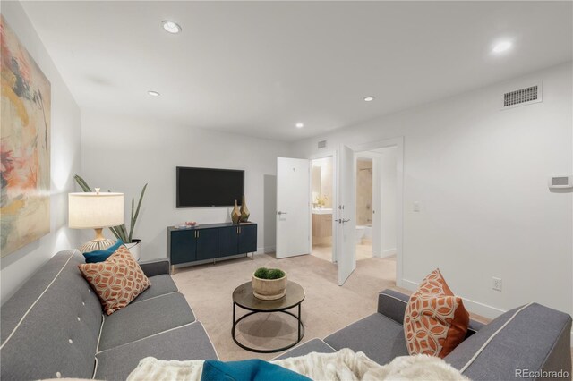 living room with recessed lighting, light carpet, and baseboards