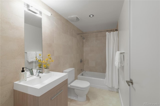 full bathroom featuring tile walls, shower / tub combo with curtain, toilet, vanity, and tile patterned flooring