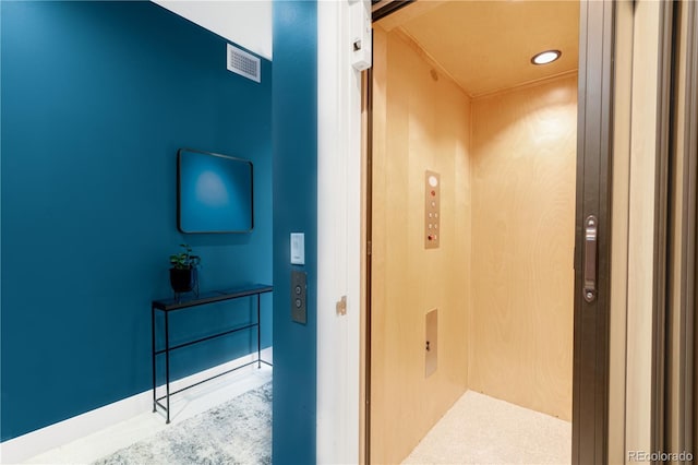 hallway with elevator and recessed lighting