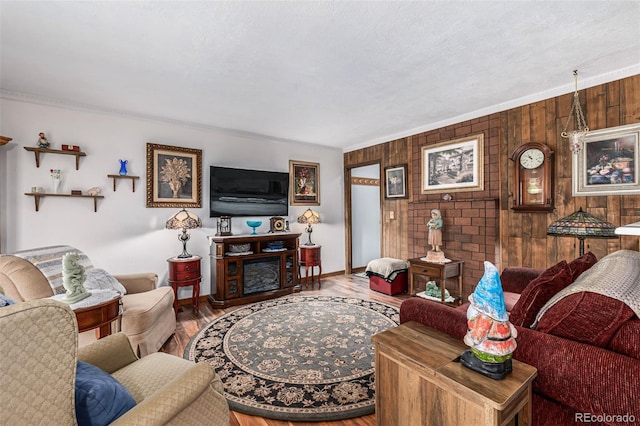 living room featuring hardwood / wood-style floors, wood walls, and ornamental molding