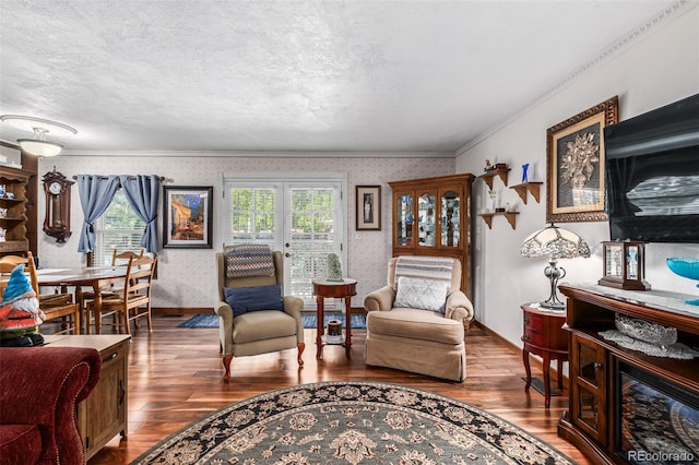 living room featuring a healthy amount of sunlight, dark wood-type flooring, a textured ceiling, and ornamental molding