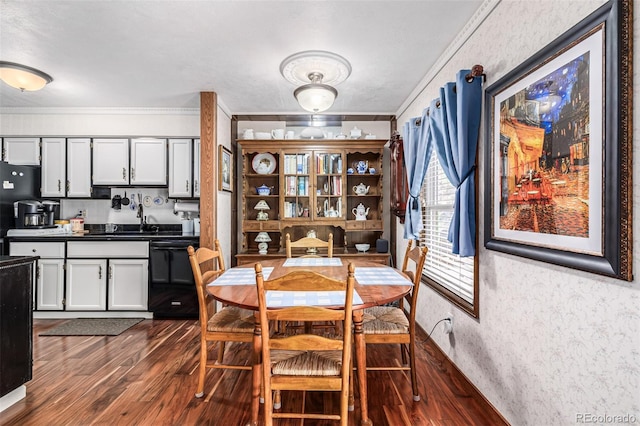 dining area featuring dark hardwood / wood-style floors, ornamental molding, and sink